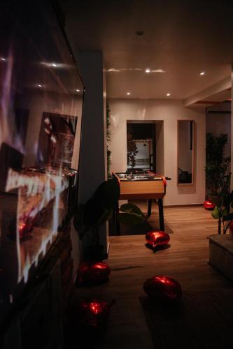 a living room with a tv and a pool table at Capsule Thailande I Sauna I Balnéo I Console I jeux en bois I Cinéma I cour intérieure in Trith-Saint-Léger