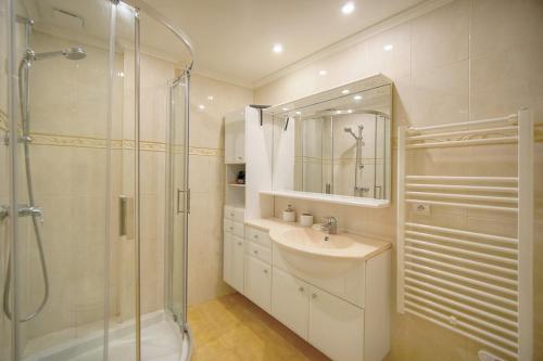 une salle de bain blanche avec une douche et un lavabo dans l'établissement FRGK - Le Dauphin - Juan les pins, à Antibes