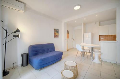 un salon avec un canapé bleu et une table dans l'établissement FRGK - Le Dauphin - Juan les pins, à Antibes