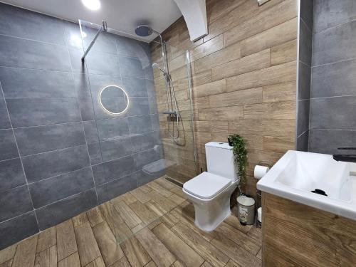 a bathroom with a toilet and a shower and a sink at Iconic Studio Valletta in Valletta
