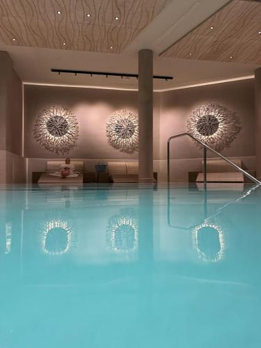 a room with a swimming pool with two mirrors at SlowDown Bottsand Hotel und Spa in Wendtorf