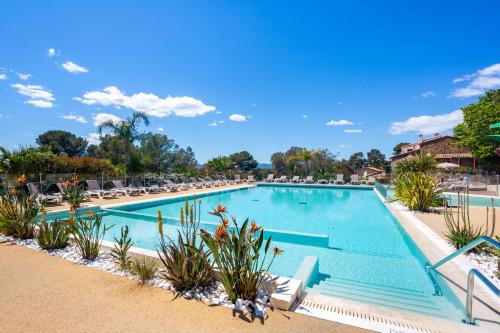 une piscine dans un complexe hôtelier avec des chaises longues dans l'établissement Mobile-home magnifique vue mer camping 4 etoiles, à Saint-Raphaël