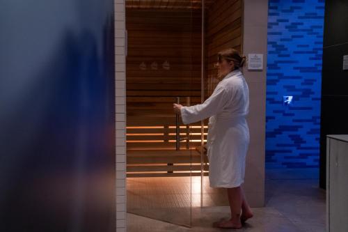 a woman in a white dress standing next to a chair at SlowDown Bottsand Hotel und Spa in Wendtorf