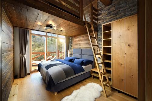 a bedroom with a bunk bed and a ladder at Chalet Oasis - Luxury Retreat at Chalets Kvačianska Dolina in Zuberec