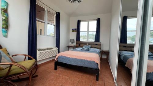 a bedroom with a bed and a chair and a mirror at Costa Ensenada Penthouse 505 across the street from Balneario beach in Rincon