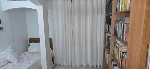 a bedroom with a bed next to a book shelf at Espaço TOP São Paulo - Brazil in Sao Paulo