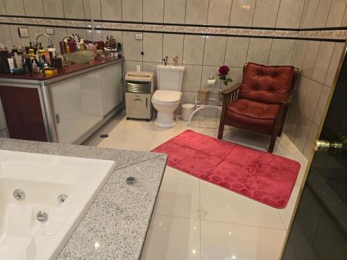 a bathroom with a sink and a toilet and a chair at Espaço TOP São Paulo - Brazil in Sao Paulo