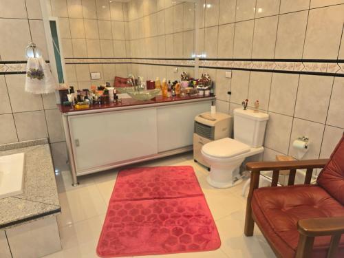 a bathroom with a toilet and a red rug at Espaço TOP São Paulo - Brazil in Sao Paulo