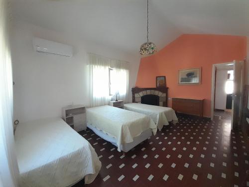 La Casa de los Gisitos في ريو سيبالوس: غرفة نوم بسريرين وجدار برتقالي