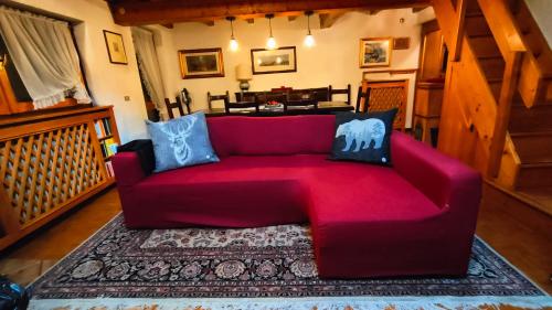 a red couch sitting in a living room at Appartamento Fronte Piste in Auronzo di Cadore