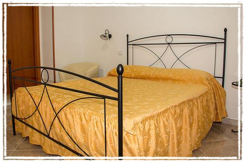a bedroom with a bed with a yellow comforter at A Pastaiola in Cetara