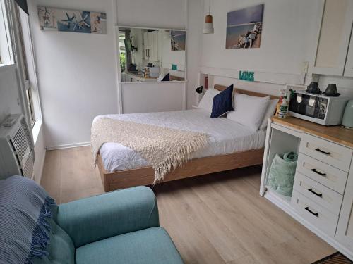 a small bedroom with a bed and a couch at Forest view bungalow in Nambucca Heads