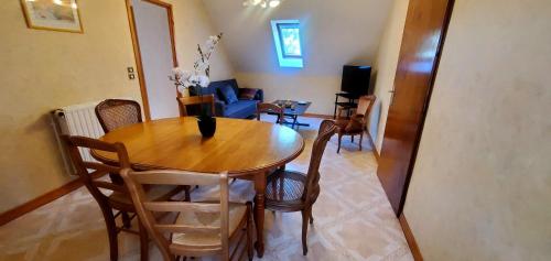 a dining room with a wooden table and chairs at Le logis de l'Ajolaise in Vielle-Aure
