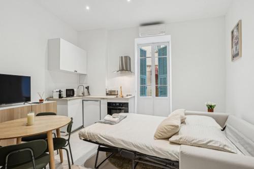 un salon blanc avec un canapé et une table dans l'établissement La Promenade Niçoise, à Nice