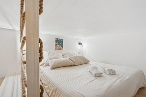 une chambre avec un lit blanc avec des serviettes dessus dans l'établissement La Promenade Niçoise, à Nice