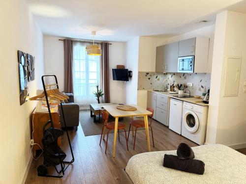 eine Küche und ein Wohnzimmer mit Tisch und ein Esszimmer in der Unterkunft Le Confetti ! in Sète