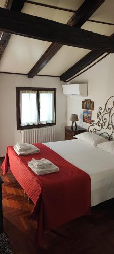 a bedroom with a large bed with a red blanket at Cà del paradiso in Venice