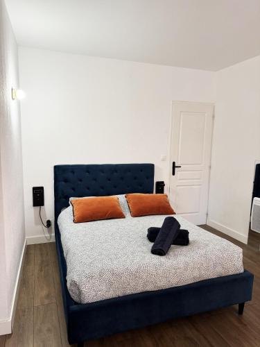 - un lit avec des oreillers orange dans l'établissement L' Oursin, à Sète