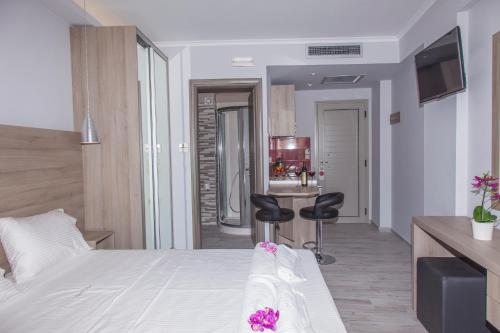 a hotel room with a bed and two black chairs at Aggelos Apartments & Deluxe Studios in Nydri