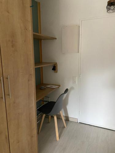a room with a chair and a desk and a door at Le petit chalet in Lamalou-les-Bains