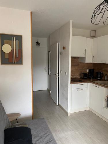 une cuisine avec des armoires blanches et un comptoir dans l'établissement Le petit chalet, à Lamalou-les-Bains