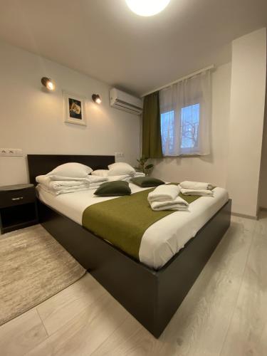 a bedroom with a large bed with a green blanket at Pensiunea Pictorilor in Baia Mare