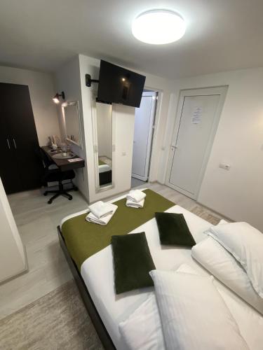 a bedroom with a bed with two pillows and a desk at Pensiunea Pictorilor in Baia Mare