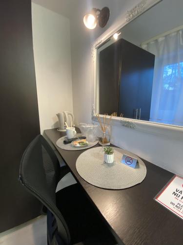 a table with two chairs and a mirror in a room at Pensiunea Pictorilor in Baia Mare