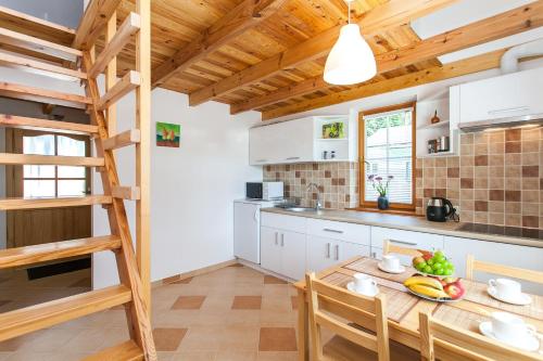 uma cozinha com uma mesa de madeira e uma escada em Svečių namelis em Druskininkai