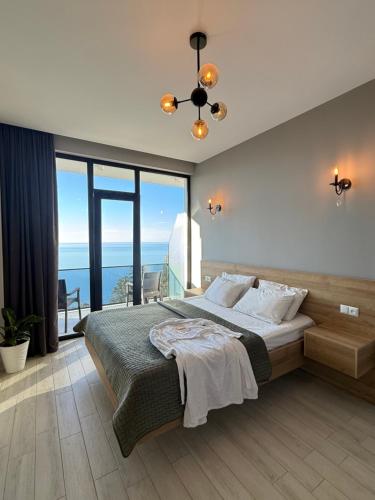 a bedroom with a large bed and a large window at Villa Deluxe Kvariati in Kvariati