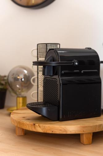 un grille-pain noir assis au-dessus d'une table en bois dans l'établissement Le Refuge Cosy - Netflix, à Massy