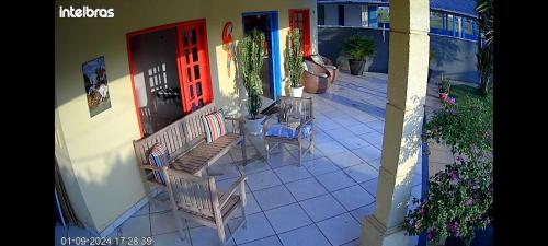 eine Veranda mit zwei Stühlen und einer Bank vor einem Haus in der Unterkunft Casa mobiliada tipo chácara para cop30 in Benfica