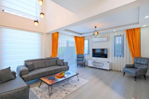 un salon avec un canapé et une télévision dans l'établissement Simge 1, à Fethiye