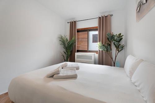 a white bed in a room with a window at Apartamento Delfin Amarillo in Santiago del Teide