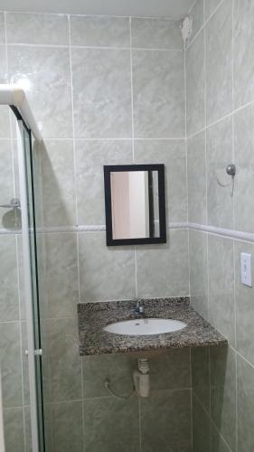a bathroom with a sink and a mirror at Apartamento Brisa 201 in Pedra de Guaratiba