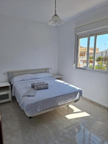 a bedroom with a bed and a window at Casa La Mata in Torrevieja