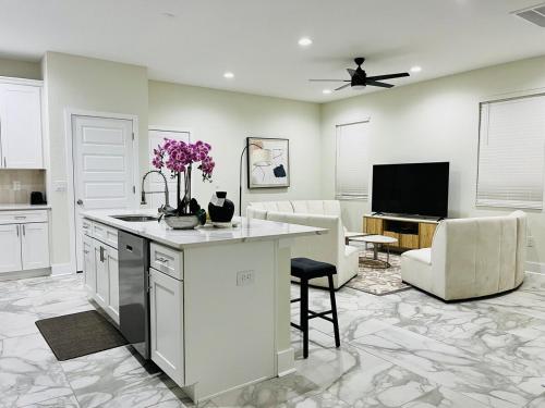a kitchen and living room with a counter and a tv at Spacious Modern 5-Bedroom House, Close to Downtown Tampa in Tampa