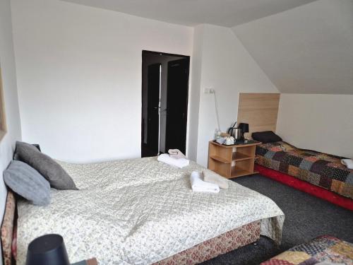 a hotel room with a bed and a night stand at Penzion Oráč in Velemín
