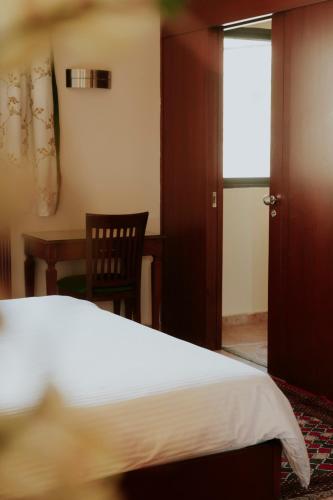 a bedroom with a bed and a table and a chair at Le Cedrus Hotel in Al Arz