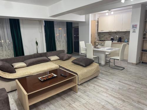 Una sala de estar con un sofá y una cocina. en Apartament 3 camere lux cu terasă - Central Universitatea din Craiova - PARCARE GRATUITĂ, en Craiova