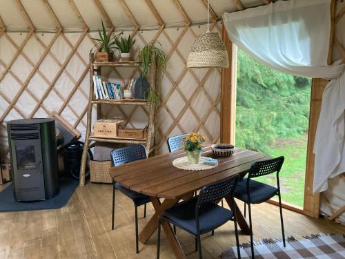 - un tavolo e sedie in legno in una yurta di Aughavannagh Yurt Glamping a Aughrim