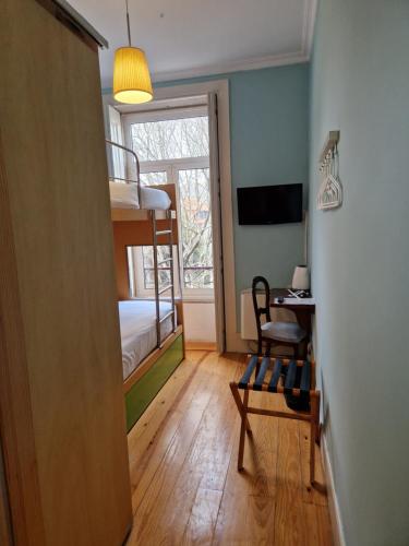 a room with a bunk bed and a desk and a chair at Dukes Corner Guest House in Porto
