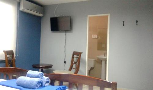 a room with a table and chairs and a television at Panama Hat Hostel in Panama City