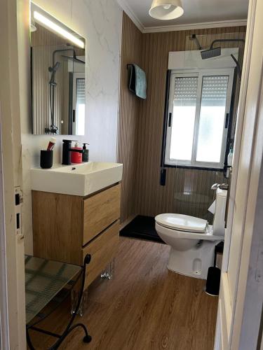 a bathroom with a sink and a toilet and a mirror at Piso centrico en Pravia, con 3 habitaciones sin ascensor in Pravia