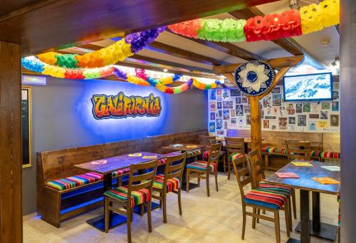 a restaurant with tables and chairs and a rainbow ceiling at Hotel Micolau in Arinsal