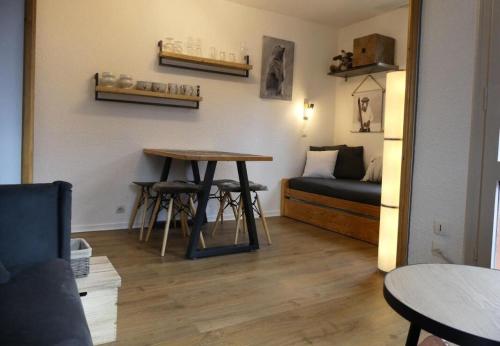 Cette chambre dispose d'une table, d'un lit et d'une table. dans l'établissement Résidence Les Chalets des Arolles - maeva Home - Charmant studio 4 personnes - Confort - Sélection MAE-9741, à Aime La Plagne