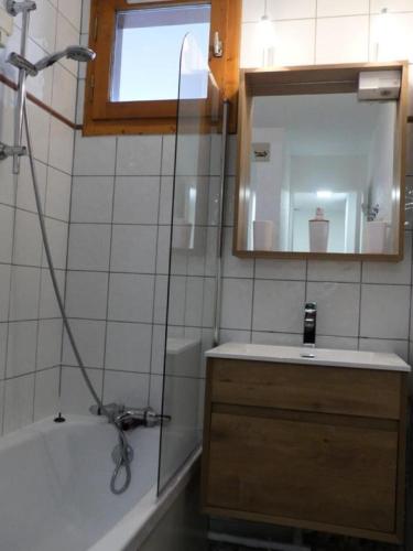 une salle de bain avec une baignoire, un lavabo et un miroir dans l'établissement Résidence Les Chalets des Arolles - maeva Home - Charmant studio 4 personnes - Confort - Sélection MAE-9741, à Aime La Plagne