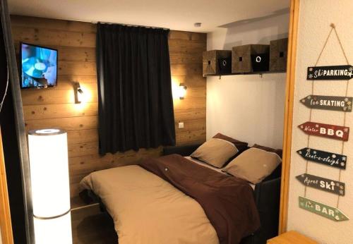 une chambre avec un lit et une télévision dans l'établissement Résidence Les Chalets des Arolles - maeva Home - Charmant studio 4 personnes - Confort - Sélection MAE-9741, à Aime La Plagne