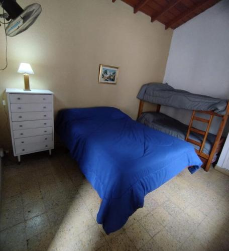 ein Schlafzimmer mit einem blauen Bett und einem Nachttisch in der Unterkunft Deptos Pablos, Apto No 4 in Villa Gesell