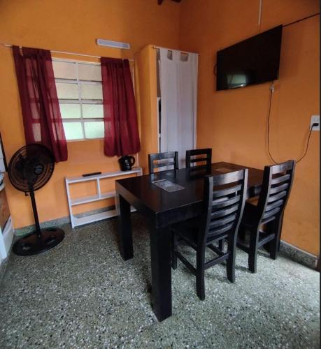 ein Esszimmer mit einem schwarzen Tisch und Stühlen in der Unterkunft Deptos Pablos, Apto No 4 in Villa Gesell